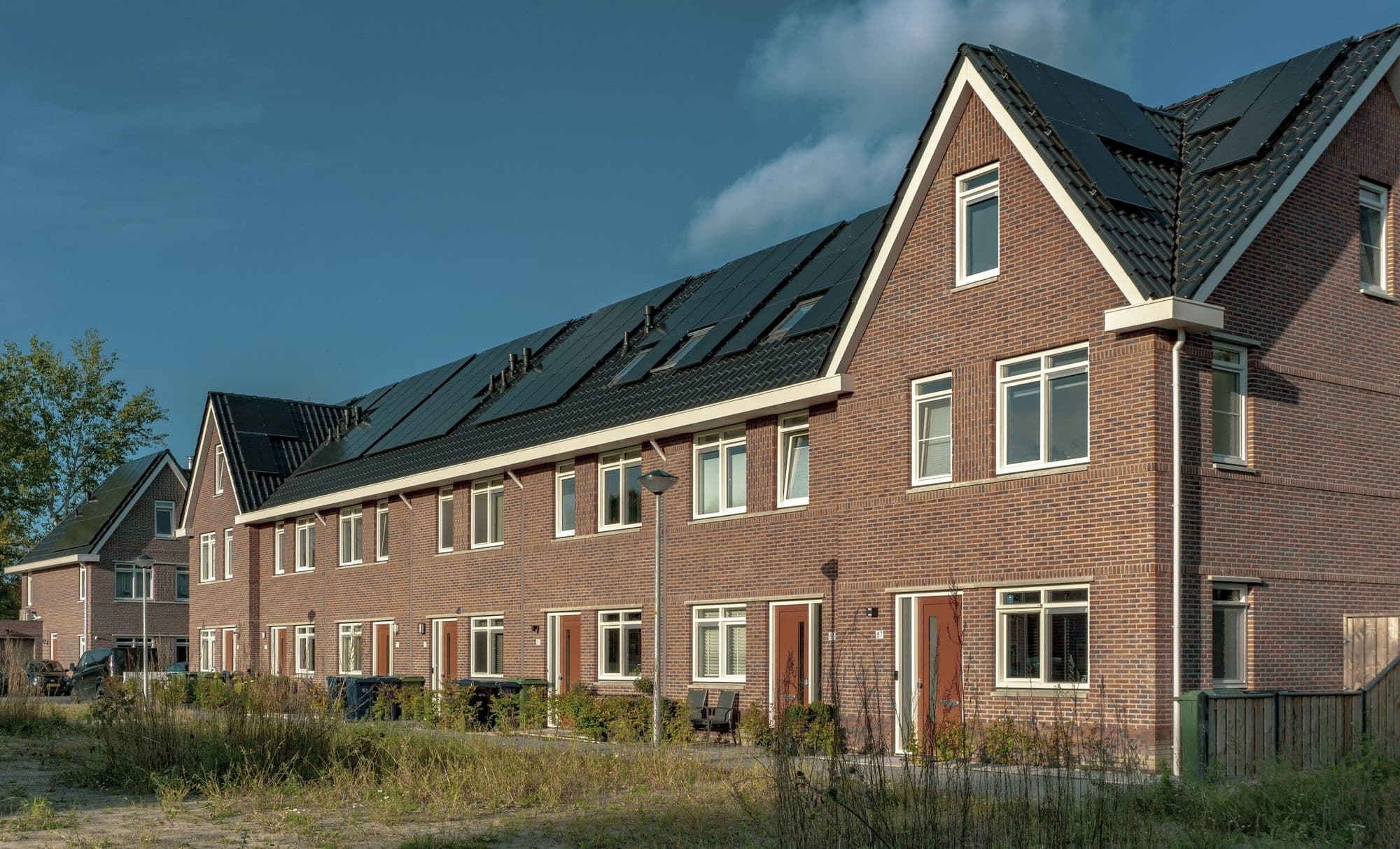 Bakstenen rijwoningen met zonnepanelen op het dak