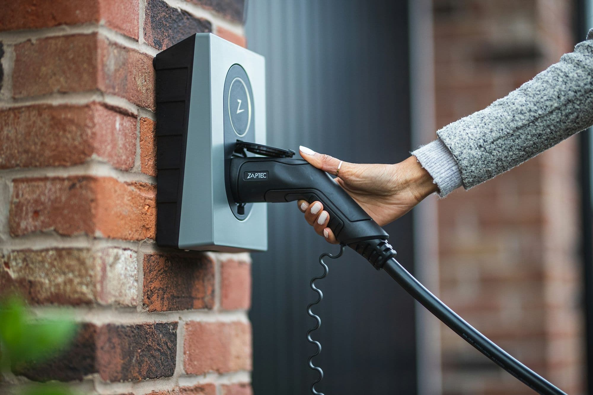 Laadkabel in een wandlader op een bakstenen muur