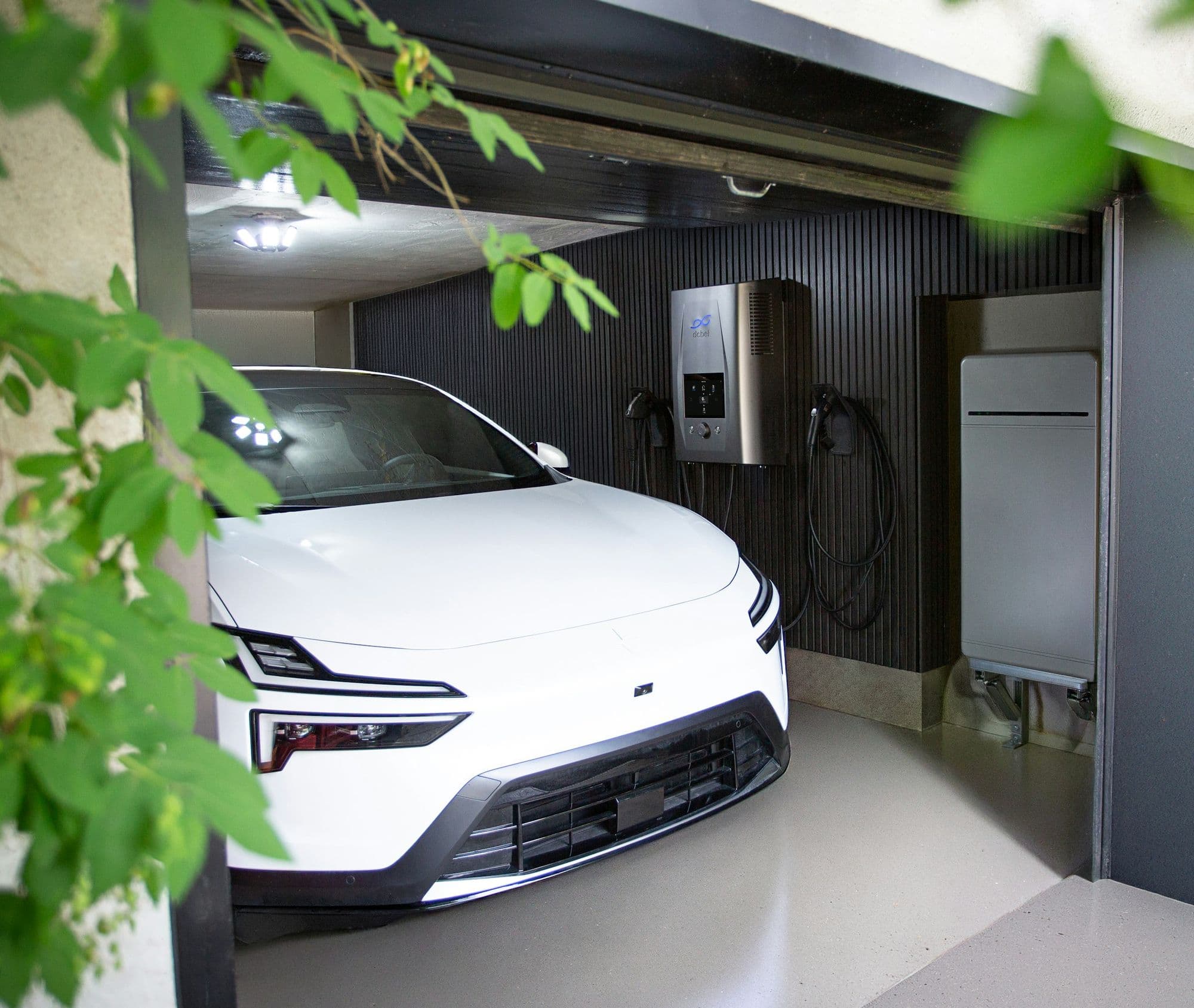 Electric car in a garage with a wall charger and a home battery